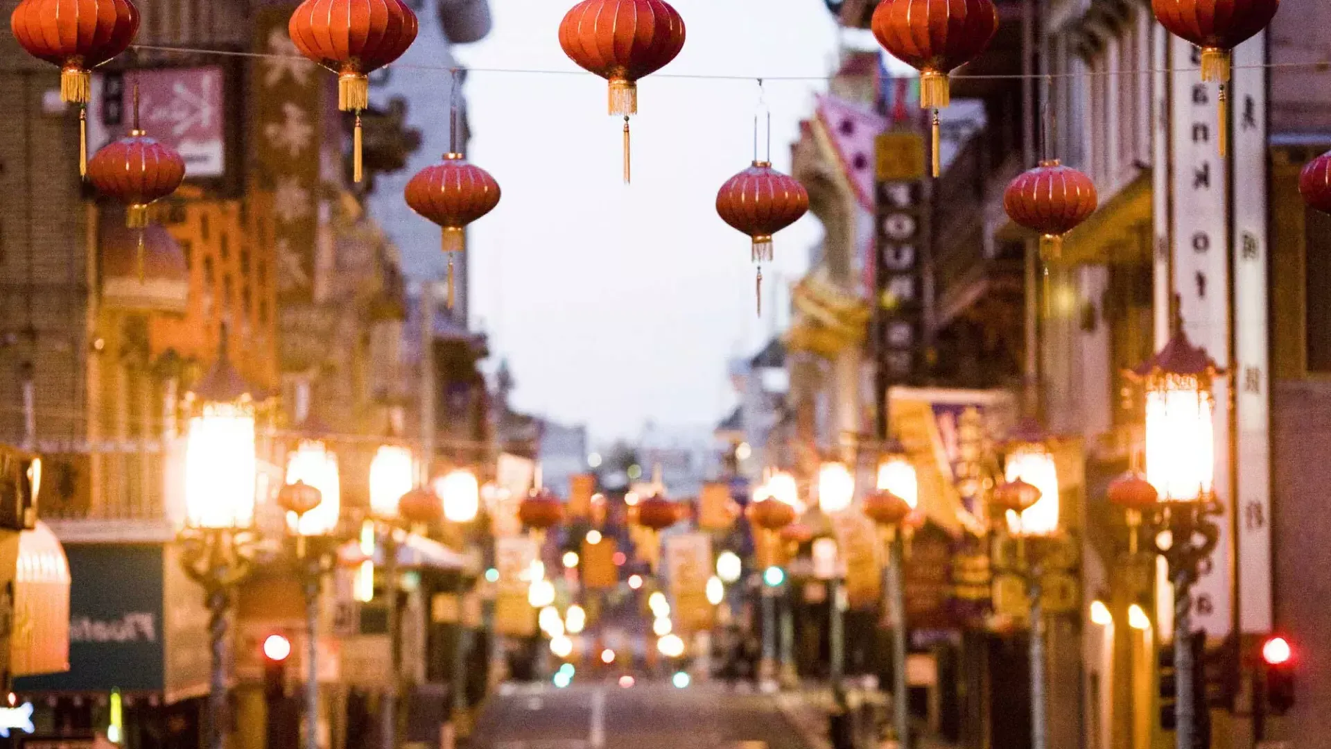 Vista en primer plano de una hilera de faroles rojos colgados sobre una calle de Chinatown , San Francisco, California.