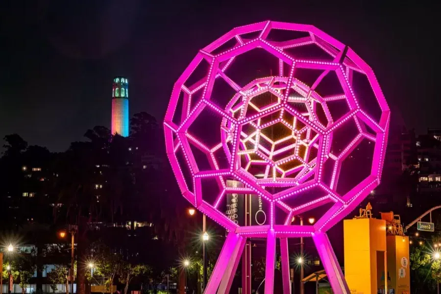 Buckyball brilla en primer plano mientras la Torre Coit brilla en la distancia.