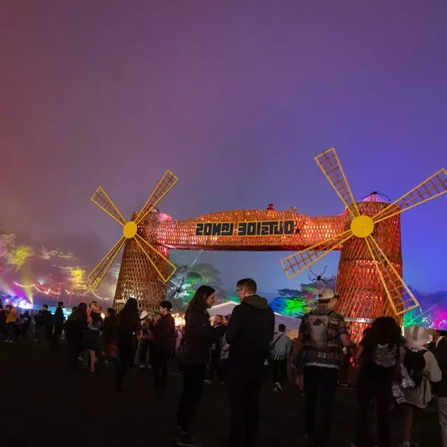 Una multitud de asistentes al festival son fotografiados de noche en medio de luces de neón en el festival de música Outside Lands en San Francisco.